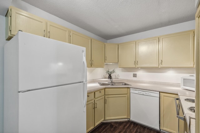 kitchen featuring sink, white appliances, cream cabinets, a textured ceiling, and dark hardwood / wood-style floors