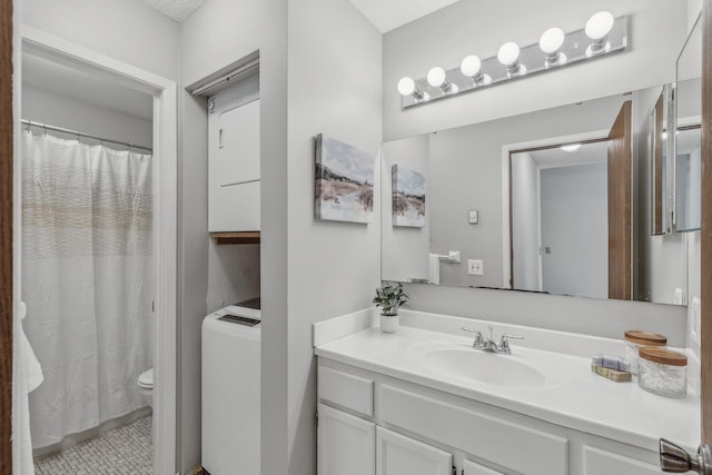 bathroom with vanity, walk in shower, toilet, and washer / clothes dryer