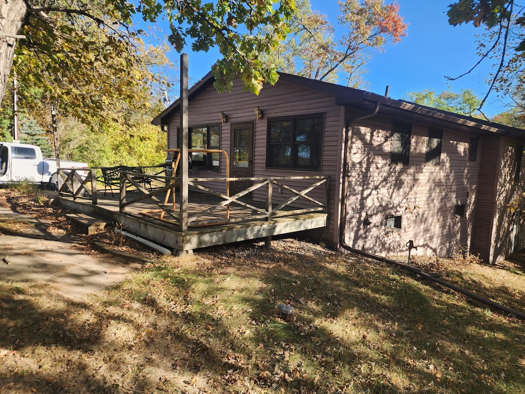 exterior space with a wooden deck and a lawn