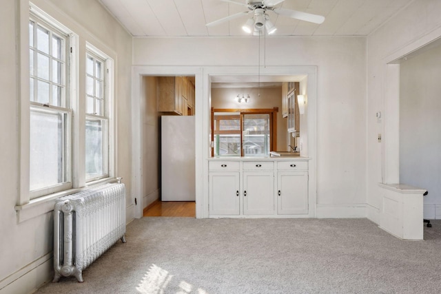 interior space with ceiling fan and radiator heating unit