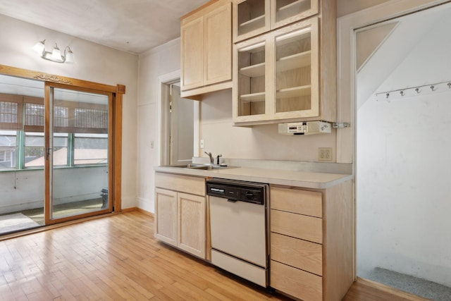 kitchen featuring light brown cabinetry, dishwasher, light wood-type flooring, and sink