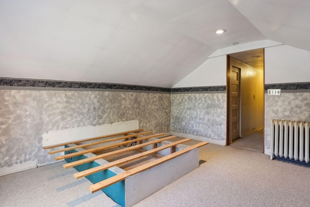 bonus room featuring vaulted ceiling, carpet flooring, and radiator