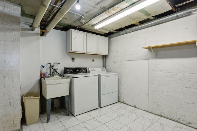 washroom featuring washing machine and clothes dryer and cabinets