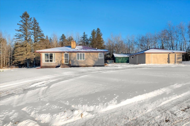 ranch-style house featuring a garage and an outbuilding