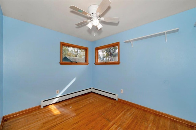 empty room featuring wood-type flooring, ceiling fan, and baseboard heating