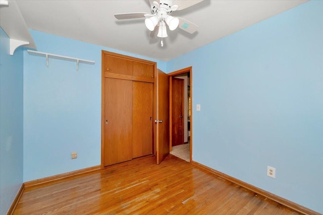 unfurnished bedroom with ceiling fan, light hardwood / wood-style floors, and a closet