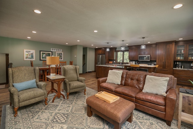 living room featuring sink and light hardwood / wood-style flooring