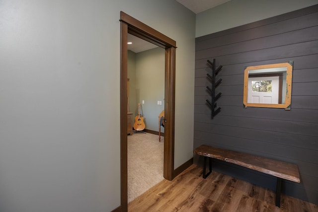 corridor with wooden walls and light hardwood / wood-style flooring