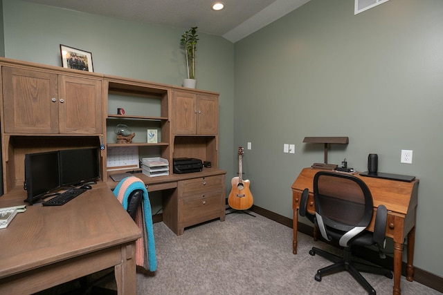 office with vaulted ceiling and light colored carpet