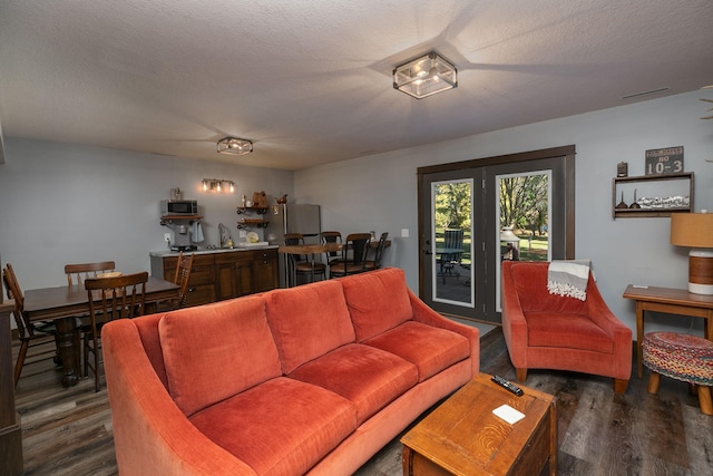 living room with a textured ceiling and dark hardwood / wood-style floors