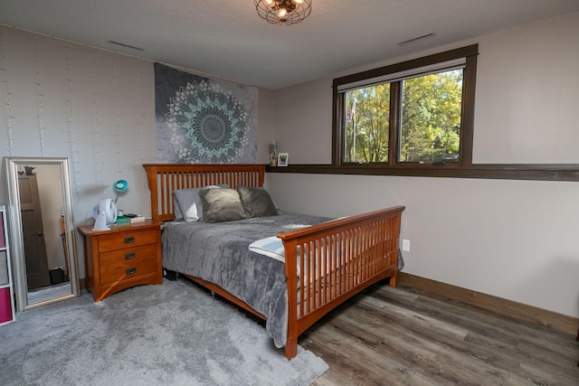 bedroom with wood-type flooring and a textured ceiling