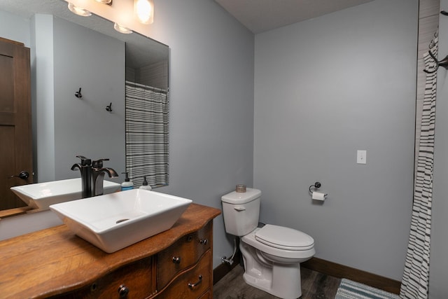 bathroom featuring wood-type flooring, vanity, and toilet