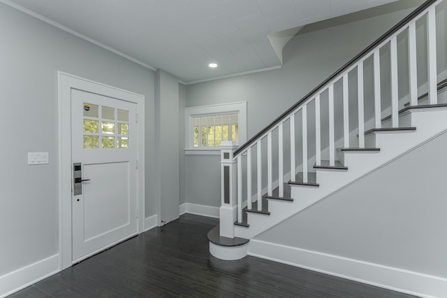 entrance foyer with ornamental molding and dark hardwood / wood-style flooring