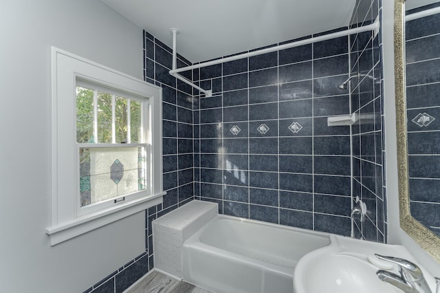 bathroom featuring tiled shower / bath combo and sink