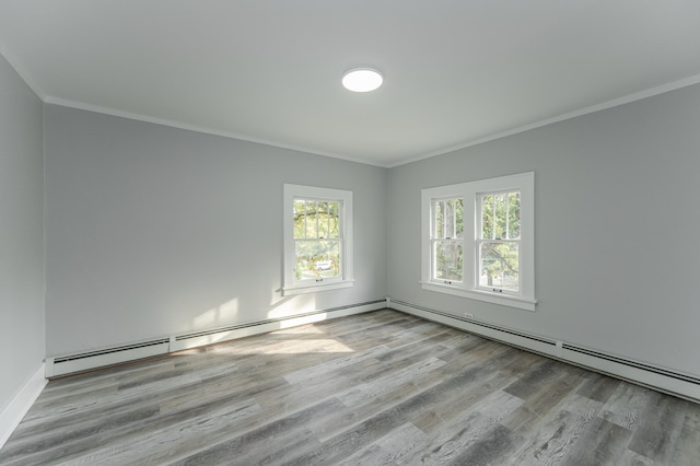 empty room featuring light hardwood / wood-style flooring, baseboard heating, and ornamental molding