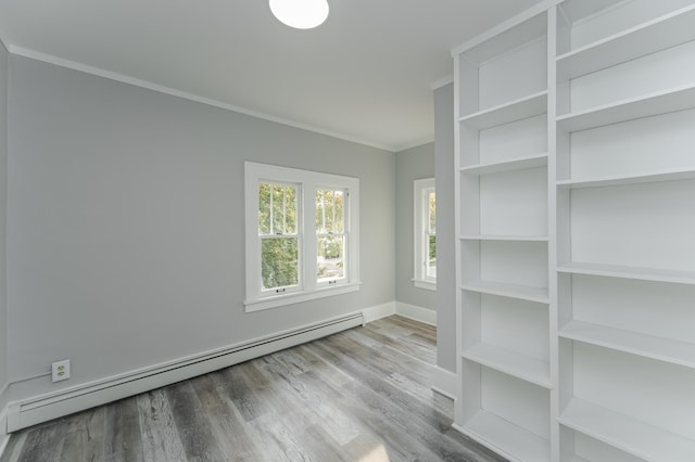 spare room featuring crown molding, light hardwood / wood-style floors, and baseboard heating