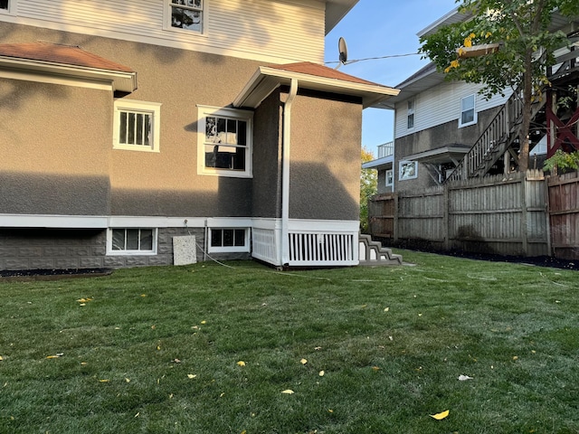 rear view of property featuring a lawn