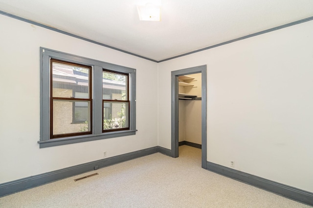 unfurnished bedroom with light colored carpet, baseboards, a walk in closet, and a closet