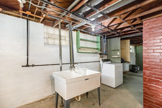 unfinished below grade area with washer / clothes dryer and a sink