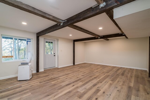 interior space with light hardwood / wood-style flooring and beam ceiling