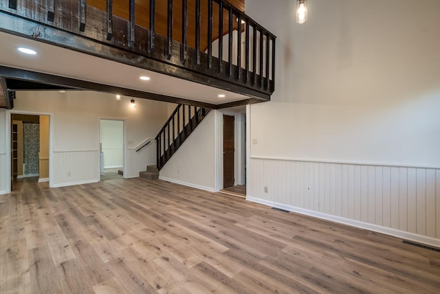 unfurnished living room with a high ceiling and hardwood / wood-style floors