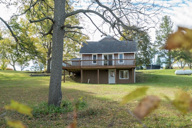 rear view of house featuring a wooden deck and a yard