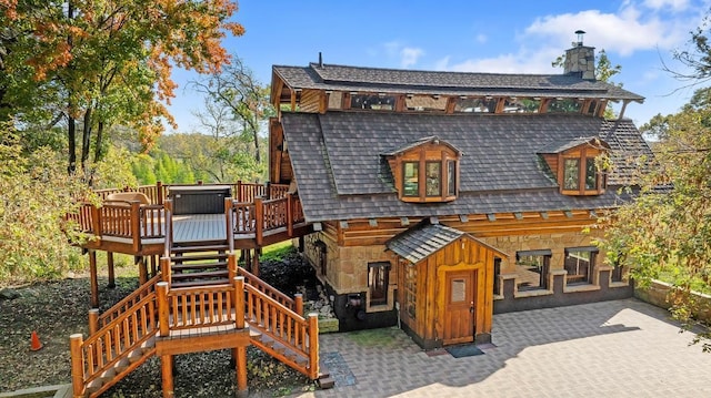 rear view of property featuring a patio area, a chimney, stairway, and a deck