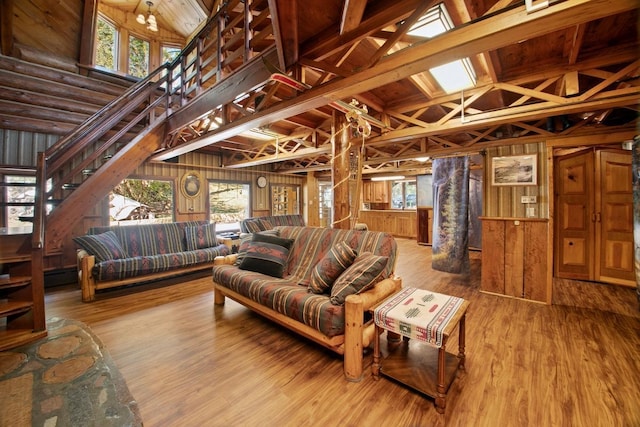 living room featuring wood walls, wood-type flooring, and vaulted ceiling with beams