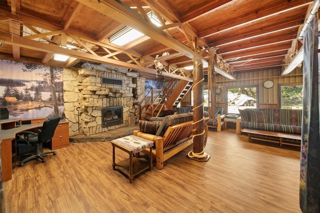 living room featuring wood-type flooring, a fireplace, beam ceiling, and wood ceiling