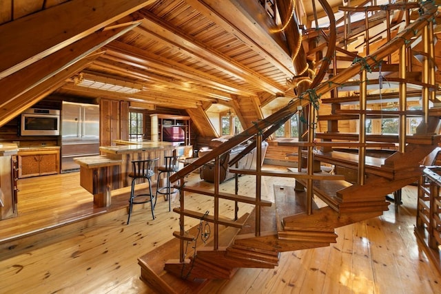 interior space featuring lofted ceiling with beams, hardwood / wood-style flooring, and wooden ceiling