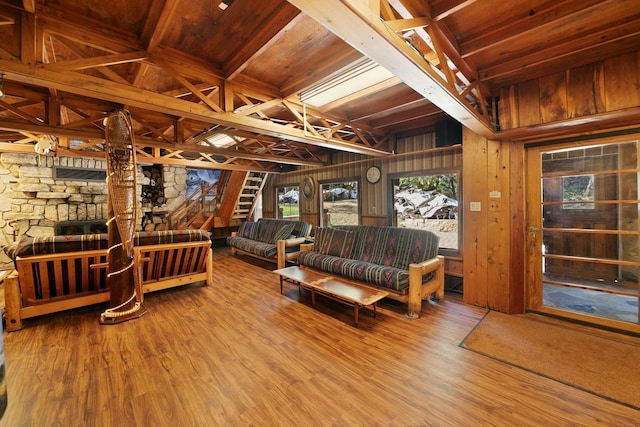 living room with wood walls, a fireplace, and wood finished floors