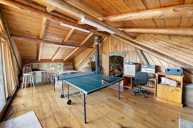 recreation room with wooden walls, wood ceiling, wood-type flooring, and lofted ceiling with beams