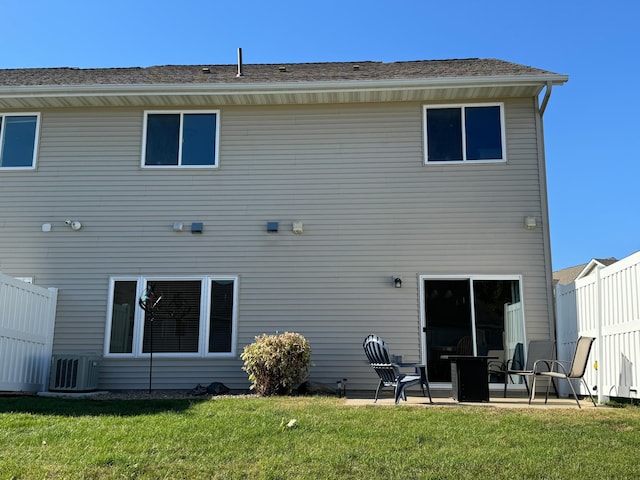 rear view of property with a patio, a yard, and central air condition unit