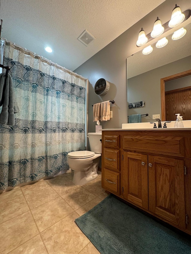 bathroom featuring a textured ceiling, tile patterned flooring, vanity, and toilet