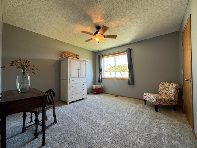 interior space with a textured ceiling, carpet floors, and ceiling fan