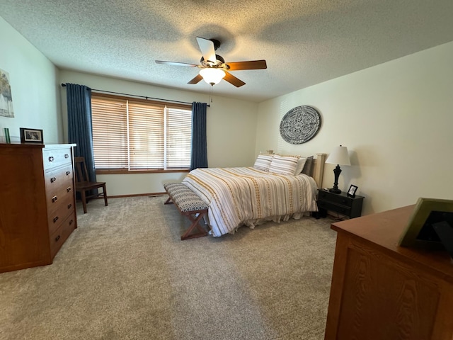 bedroom featuring a textured ceiling, light carpet, and ceiling fan