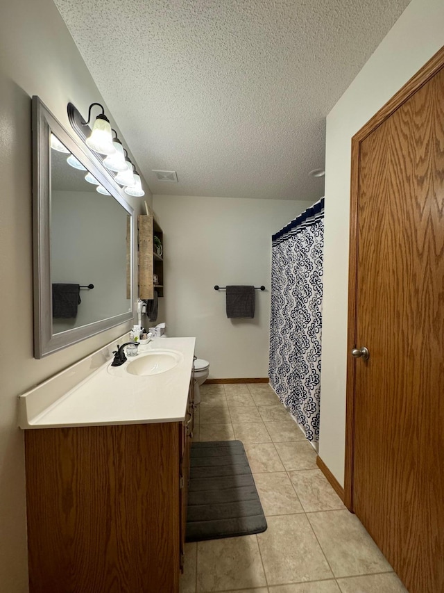 bathroom featuring a textured ceiling, tile patterned flooring, vanity, and toilet