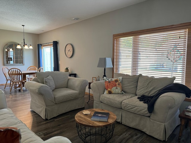 living room with a textured ceiling, hardwood / wood-style flooring, and a notable chandelier