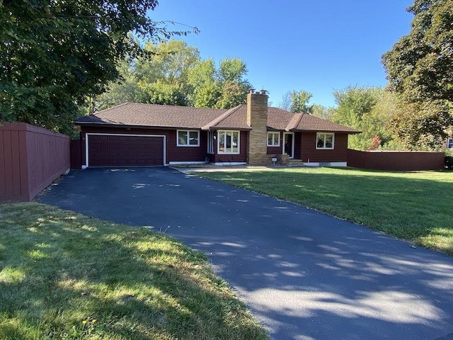 ranch-style house featuring a garage and a front lawn