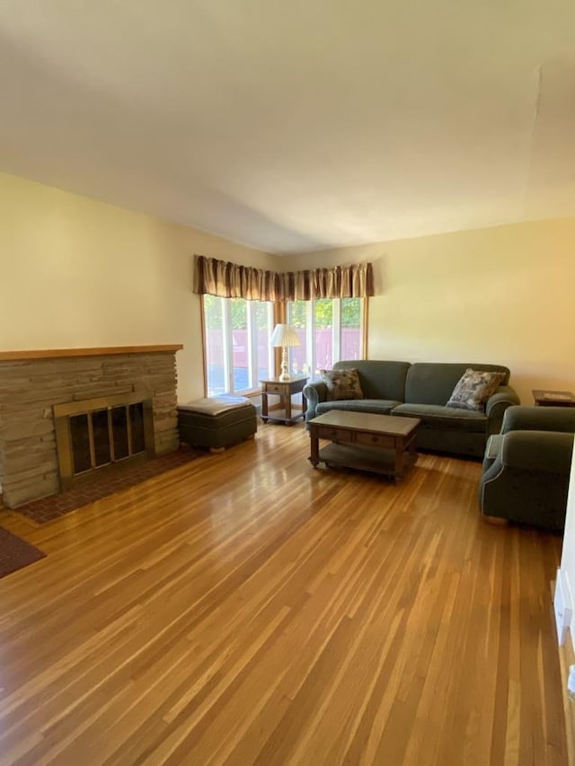 living room featuring hardwood / wood-style floors and a stone fireplace