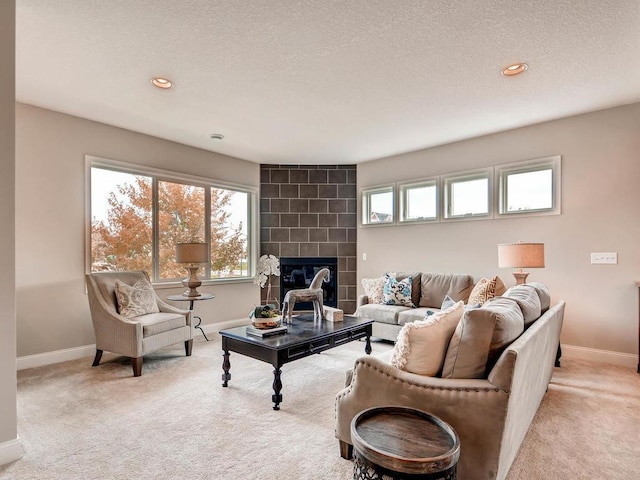 carpeted living room with a fireplace and a textured ceiling