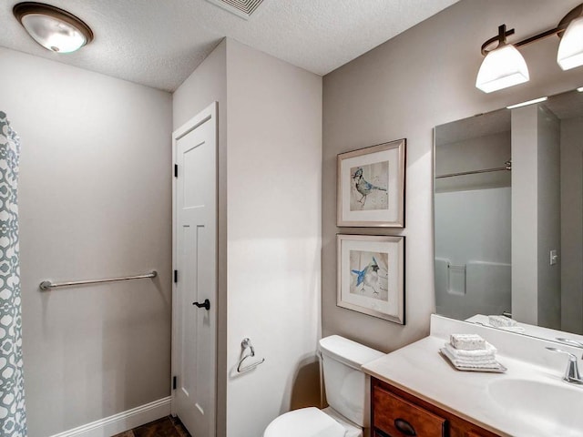 bathroom featuring vanity, toilet, and a textured ceiling