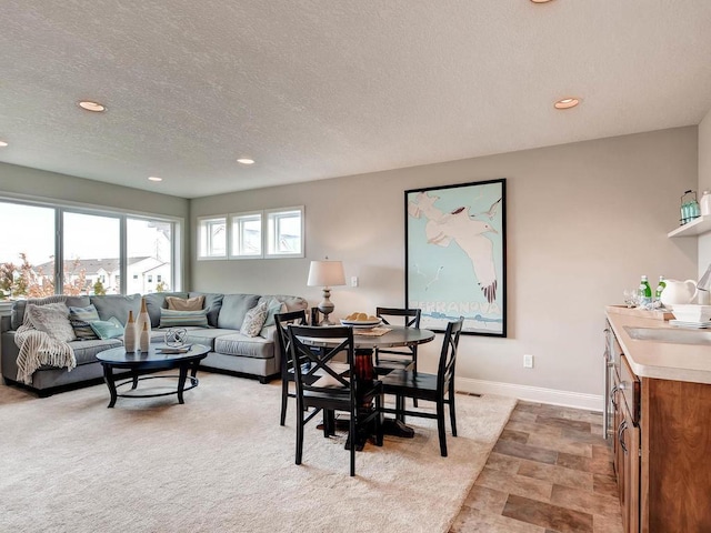 living room with light colored carpet, sink, and a textured ceiling