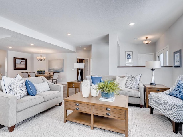 carpeted living room featuring a notable chandelier and a textured ceiling