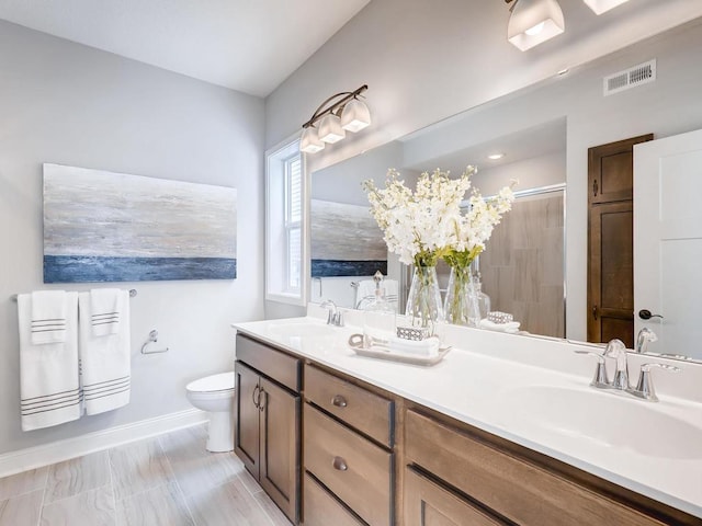 bathroom featuring walk in shower, vanity, and toilet