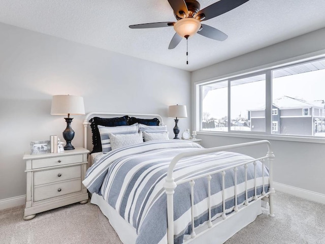 carpeted bedroom with ceiling fan and a textured ceiling