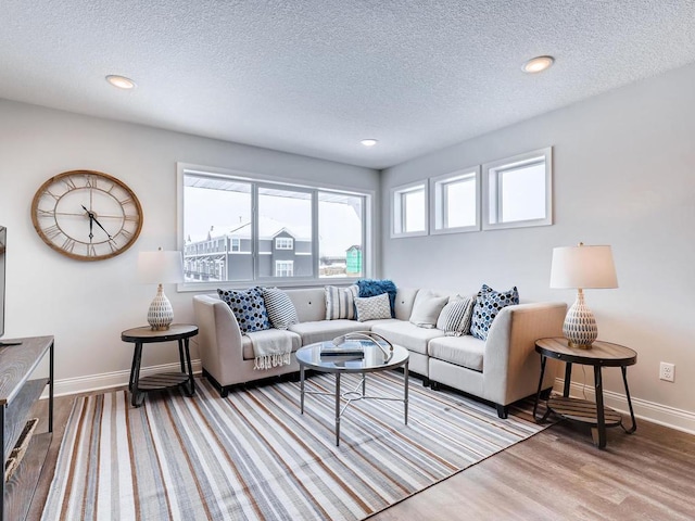 living room featuring light hardwood / wood-style floors and a textured ceiling