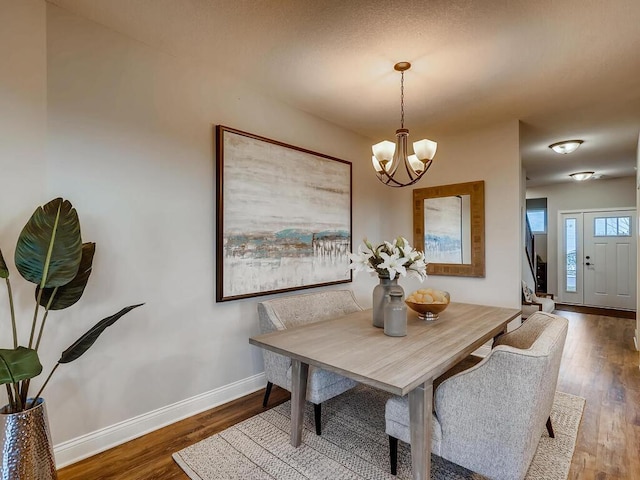 dining space with an inviting chandelier and dark wood-type flooring