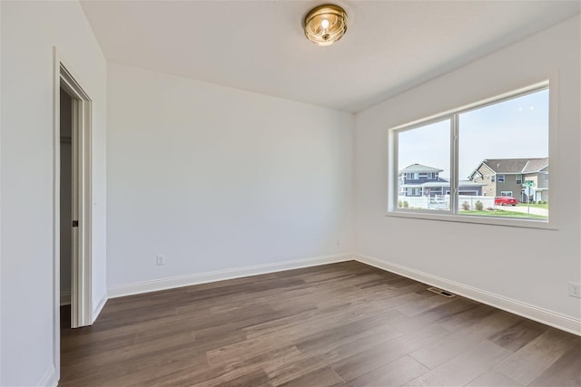 unfurnished room with dark hardwood / wood-style flooring