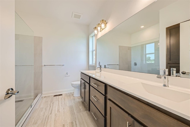 bathroom featuring a tile shower, vanity, hardwood / wood-style floors, and toilet